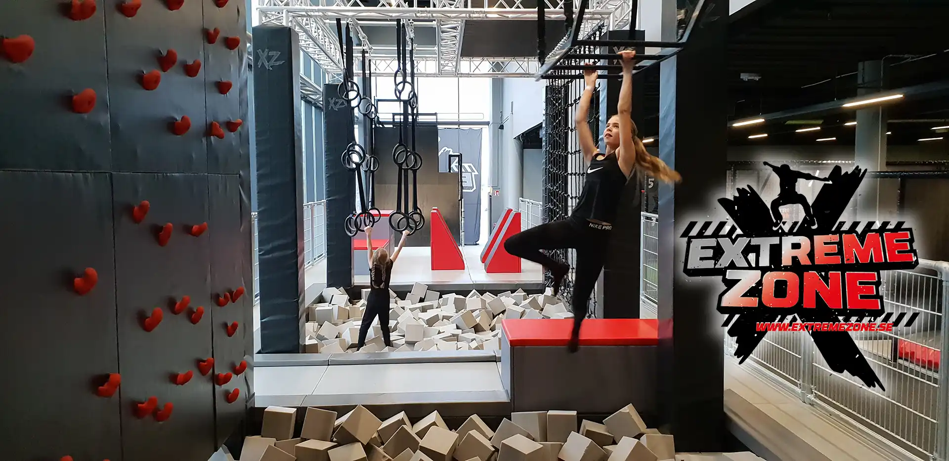 Extremezone logotyp på en bild med en tjej som klättrar på en ninja bana i en aktivitetspark.